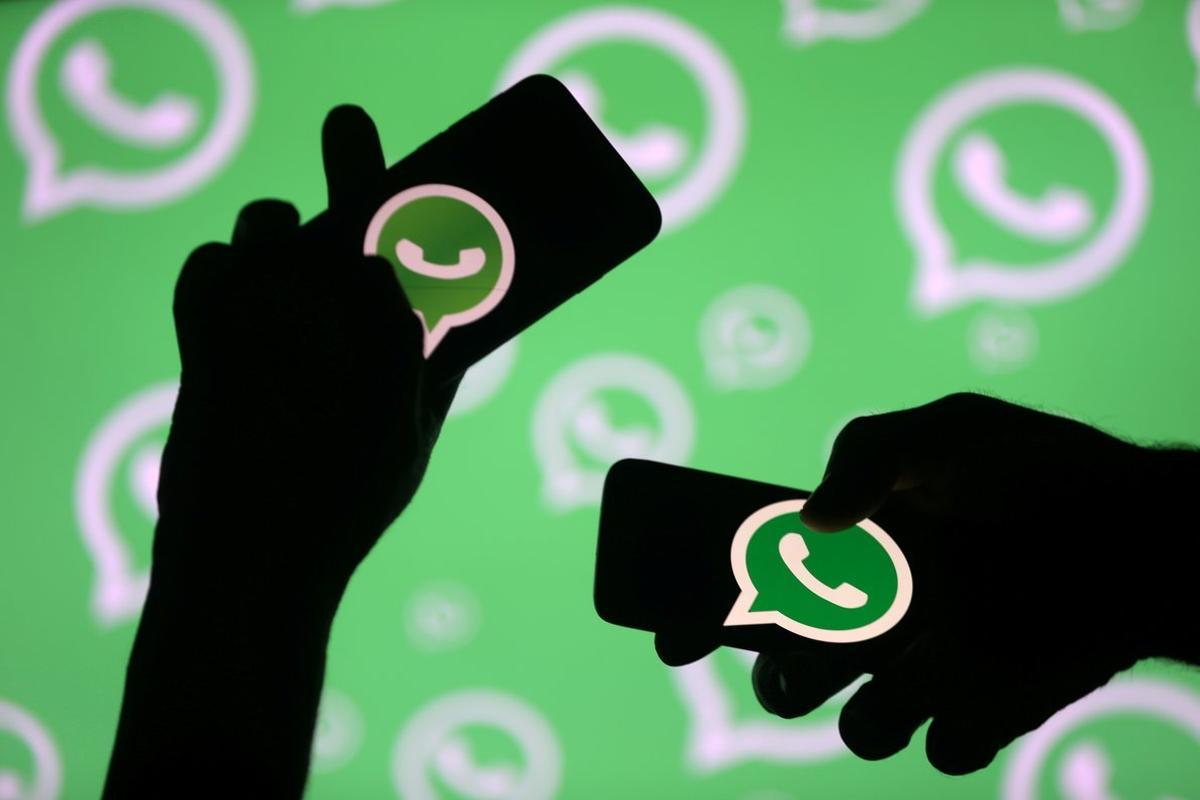 FILE PHOTO: Men pose with smartphones in front of displayed Whatsapp logo in this illustration September 14, 2017. REUTERS/Dado Ruvic/File Photo