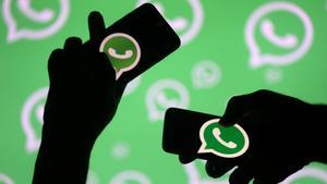 FILE PHOTO: Men pose with smartphones in front of displayed Whatsapp logo in this illustration September 14, 2017. REUTERS/Dado Ruvic/File Photo