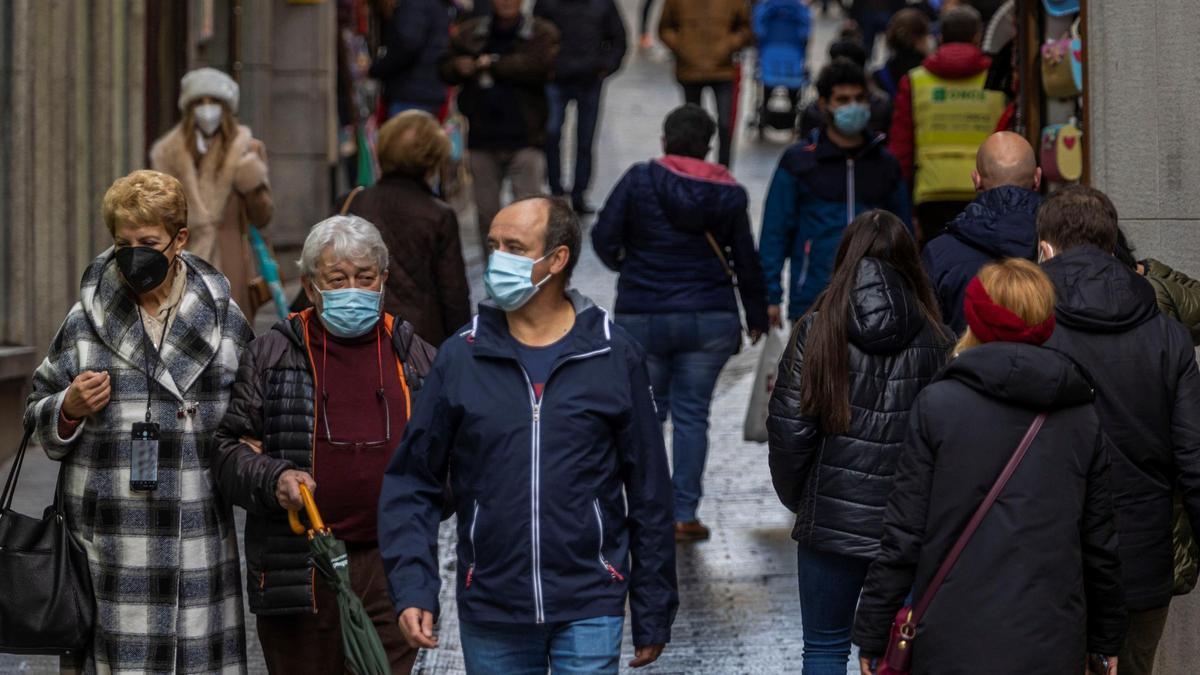 Varias personas con mascarilla en la calle.