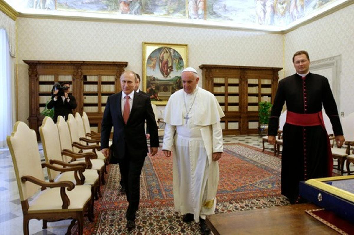 El papa Francisco camina junto a Vladímir Putin en una audiencia de 2015. El Pontífice luego criticó la guerra.
