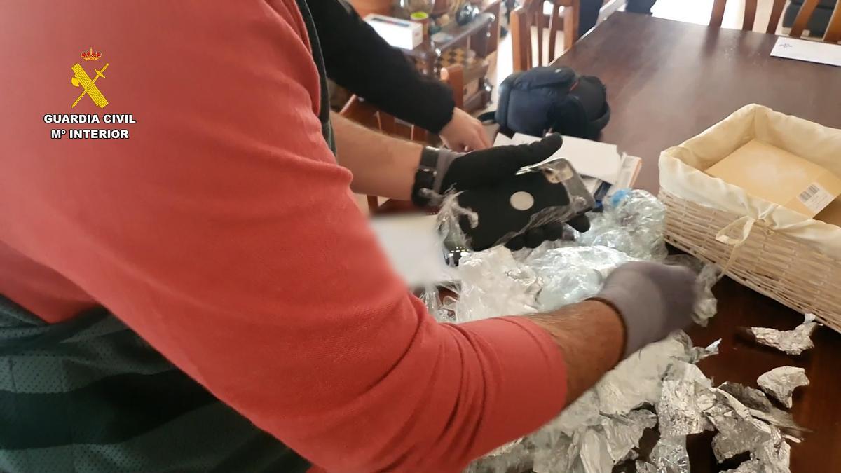 Los investigadores examinan algunos de los efectos recuperados en casa del sospechoso.