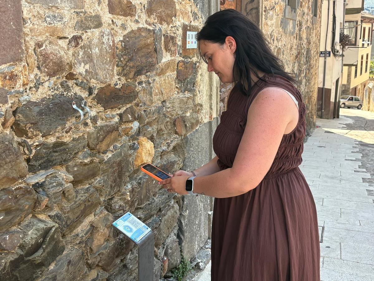 Tania Rodríguez escanea el código ante la fachada del palacio de los Llano.