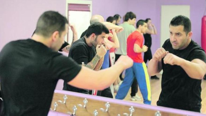 Los asistentes a una clase de krav maga realizan ejercicios técnicos en la sala del gimnasio del barrio de Laviada, donde aprenden desde hace casi dos meses.
