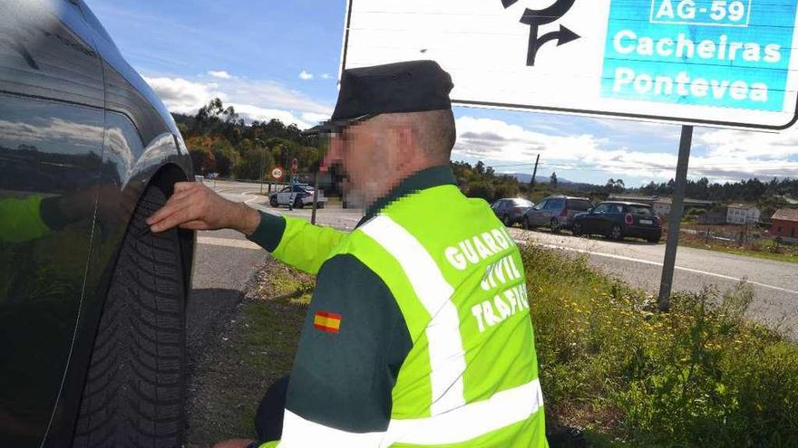 Un agente comprueba el estado de los neumáticos durante un control.