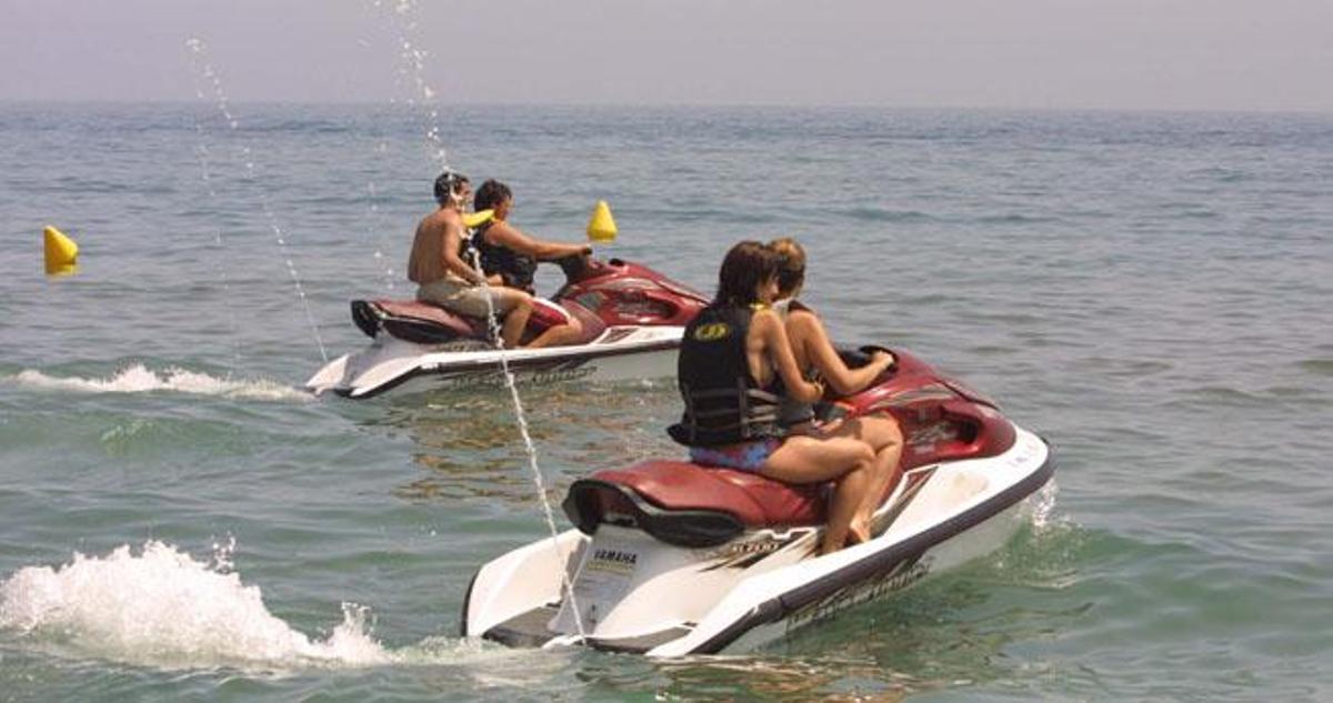 Dos motos acuáticas pasan junto a unas balizas.