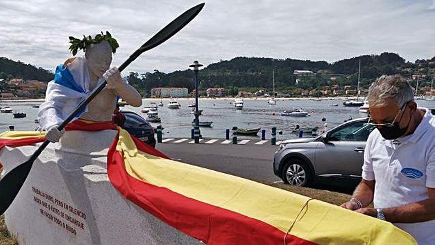 La escultura en honor a Teresa Portela engalanda con una corona de laurel y una bandera española.