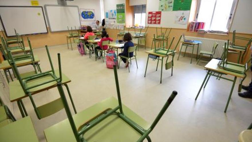 Un aula casi vacía con solo tres niñas examinándose en un colegio del centro de Pontevedra.