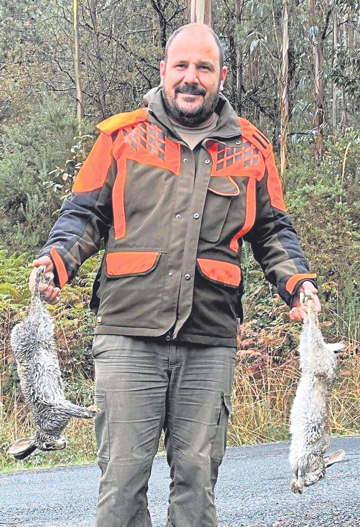 Un cazador, con dos conejos en el Monte do Carrio.