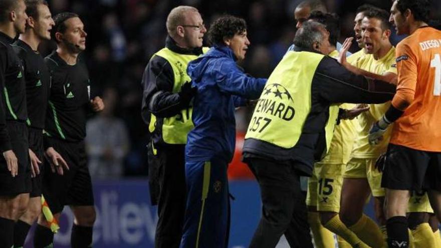 Miembros de seguridad impiden a los jugadores del Villarreal acercarse al árbitro al final del partido. / phil noble