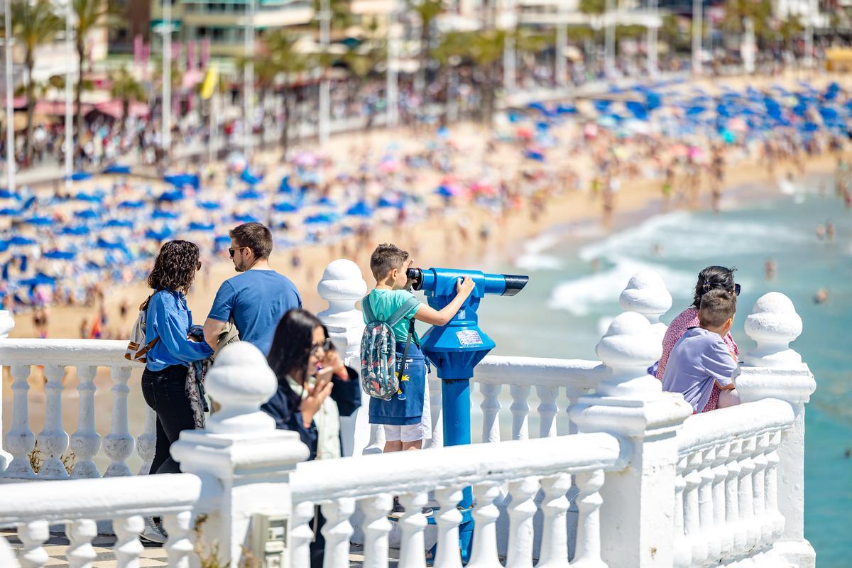 Turistas en el mirador del Castell de Benidorm, con la playa de Levante a tope de bañistas este Viernes Santo.