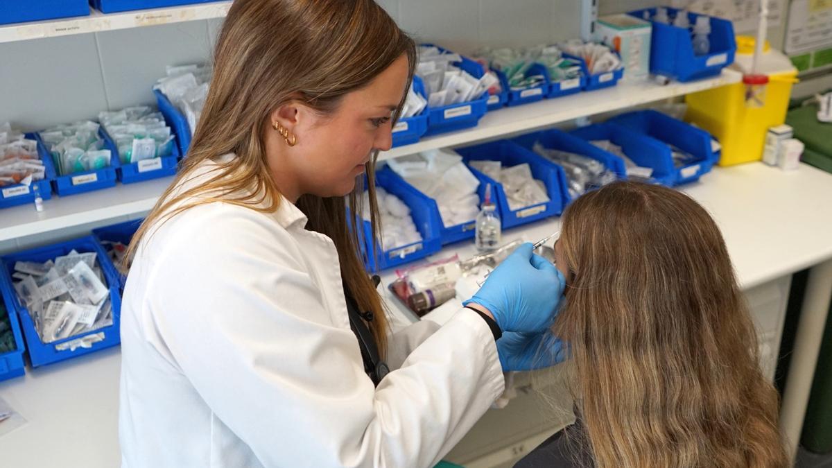 Una sanitaria inyecta bótox para la cefalea.