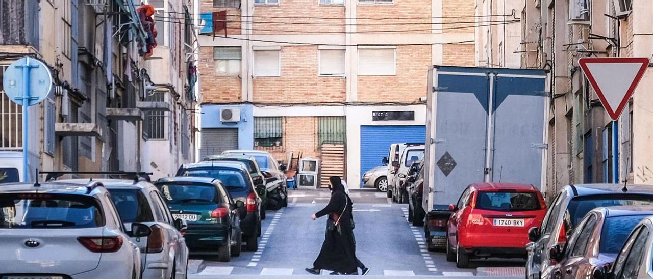 Dos mujeres de origen árabe cruzan una calle de Colonia Requena, el barrio más multicultural de Alicante.  | ÁXEL ÁLVAREZ