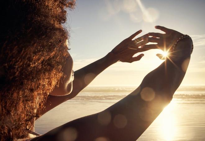 Mujer protgiéndose del sol con las manos