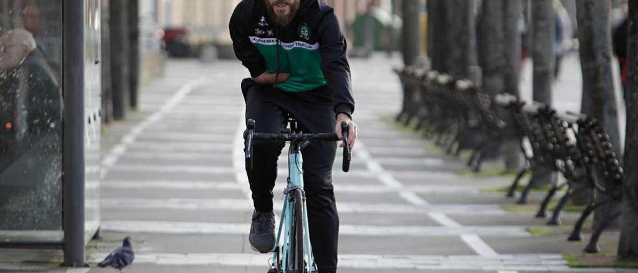 Rubén Martínez anda con su bicicleta por el carril bici en la zona del muelle deportivo de Gijón.