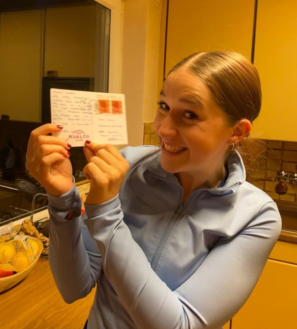 Cecilia Fisher posando con su postal desde Frankfurt.