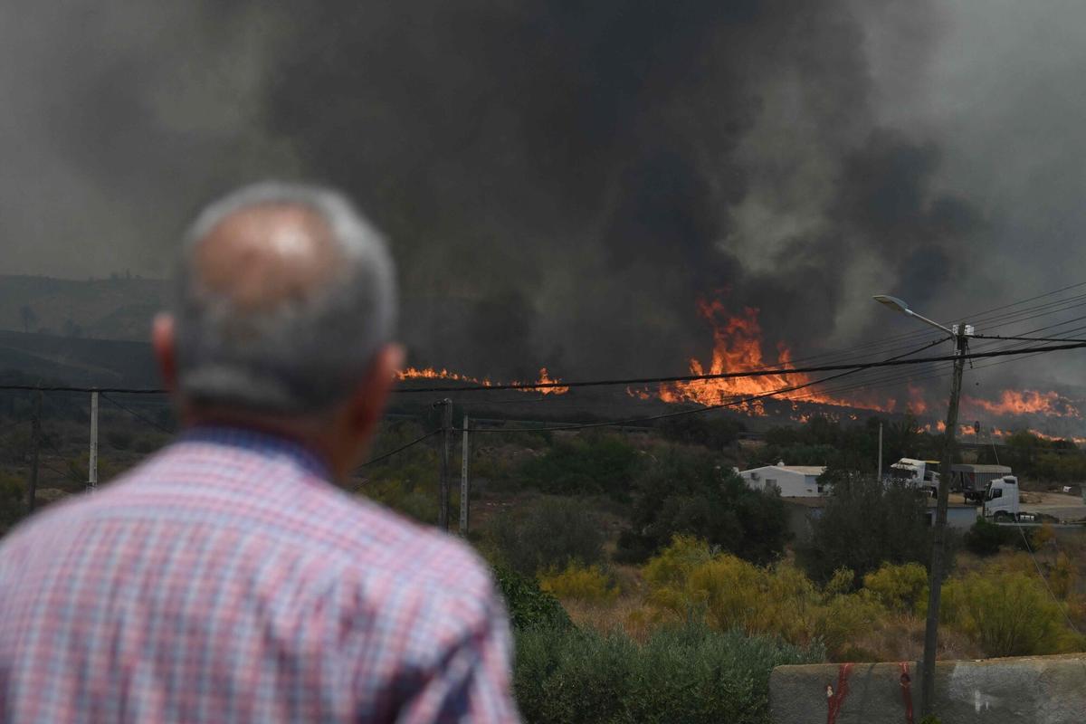 Un hombre observa llamas cerca de las casas, en el área de un incendio forestal que mató a 11 personas cerca de Bedar, en el distrito de Los Gallardos, en la provincia de Almería, el 10 de julio de 2026.