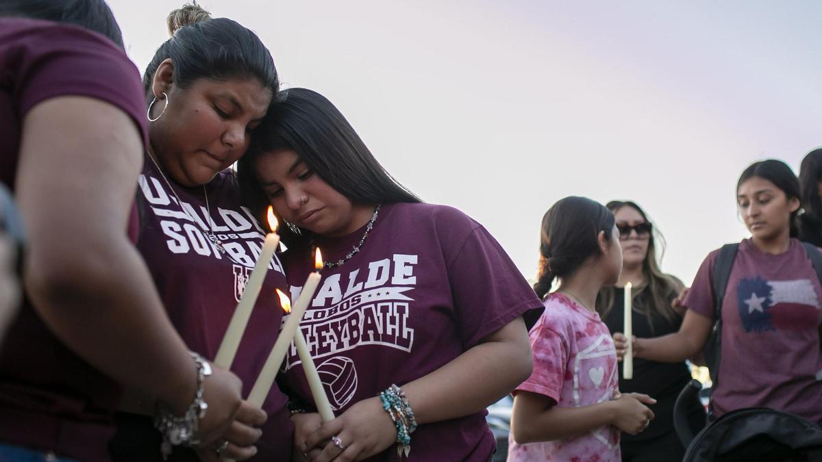 Vecinos de Uvalde  se consuelan durante una vigilia con velas celebrada en el Fairplex Arena del condado de Uvalde para honrar a las víctimas asesinadas en el tiroteo del martes en la Escuela Primaria Robb.