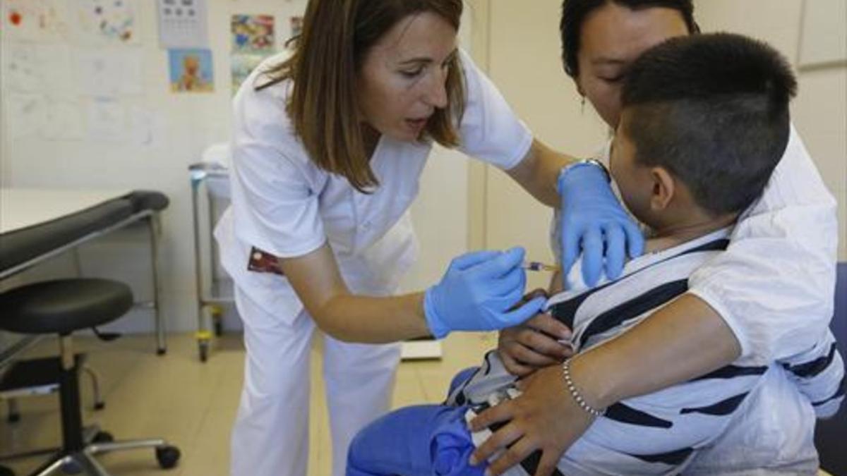 Una enfermera vacuna a un niño, el año pasado, en Sant Joan Despí.