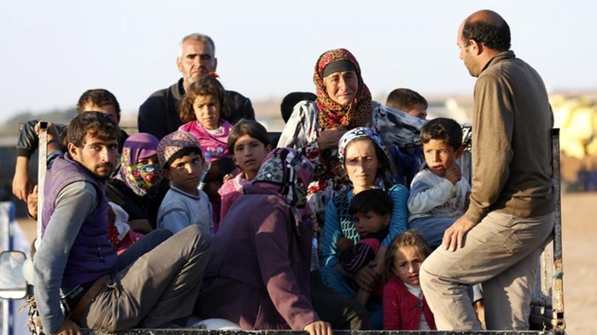 Refugiados kurdos llegados de Siria, tras entrar en Turquía, el lunes.