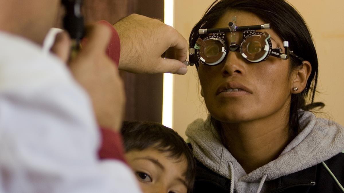 Un oftalmólogo enviado por Ojos del Mundo gradúa la vista a una mujer en Bolivia.