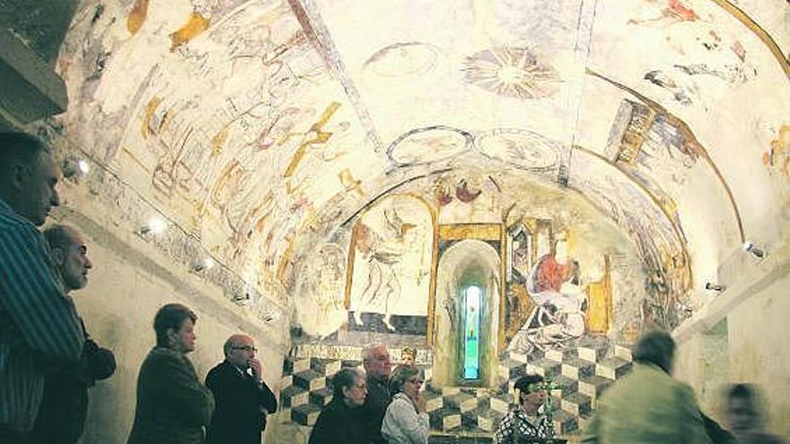 Participantes en la visita guiada a la iglesia románica de Luerces, con pinturas del siglo XVII.