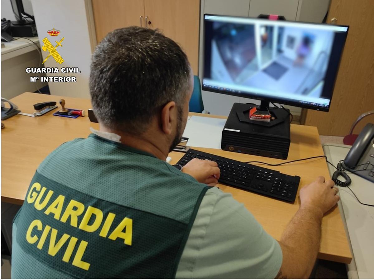 Un agente examina las grabaciones de la presunta autora de la estafa sacando dinero del cajero