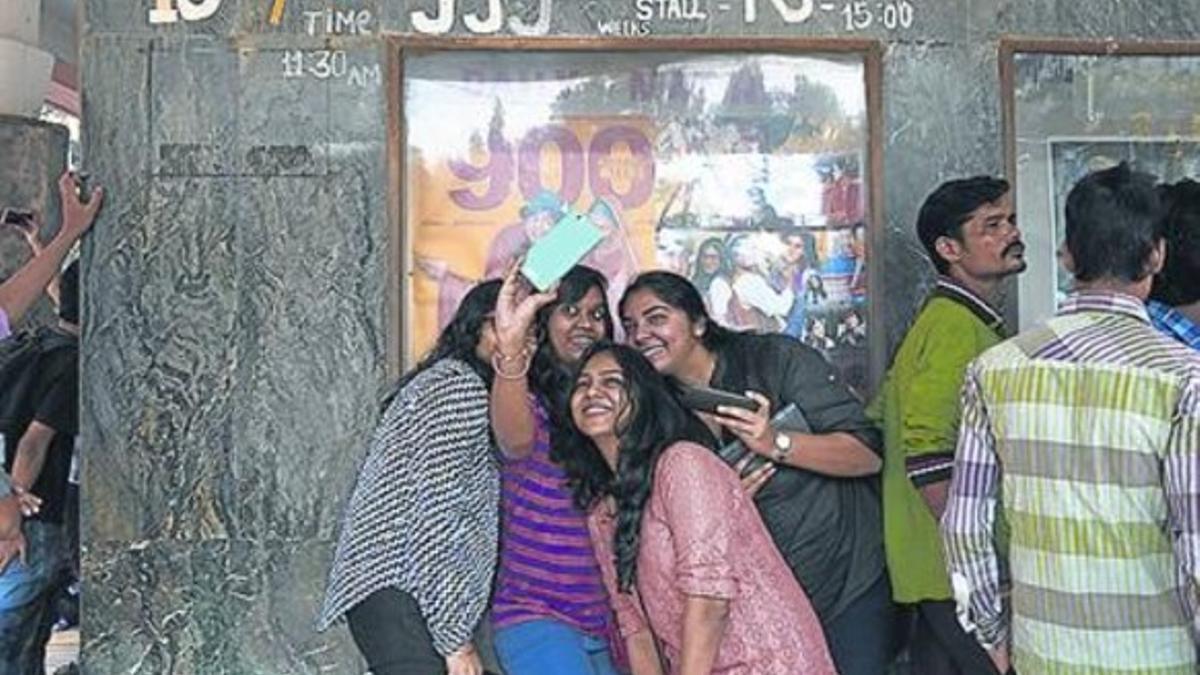 Espectadores se hacen un 'selfie' ante la puerta del cine Maratha Mandir.