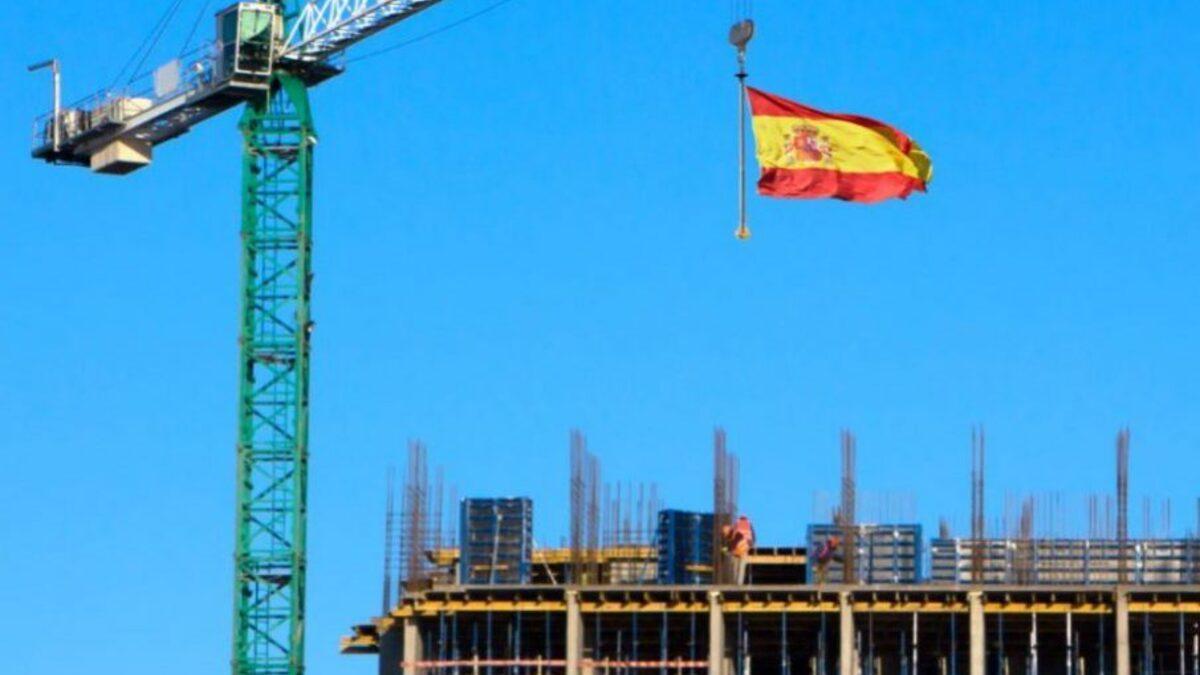 Una bandera de España siendo colocada en lo alto de una obra
