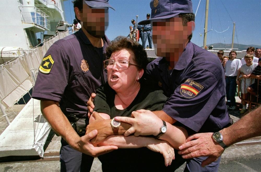 Pero la droga no ha dejado de llegar a las costas de Galicia. En la imagen, una señora intenta romper el cordón policial que protegía a la tripulación de un velero atrapado en 2001 con 1.000 kilos de cocaína y que había sido trasladado a Vilagarcía.