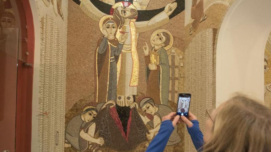 Una turista fa una foto a un dels mosaics de la Cova | ARXIU/OSCAR BAYONA