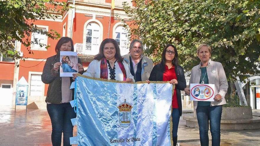 Alfombristas de Bueu junto a la edil de Turismo, Silvia Carballo, con una bandera de Bueu antes de su último viaje al Vaticano, en noviembre. // Gonzalo Núñez