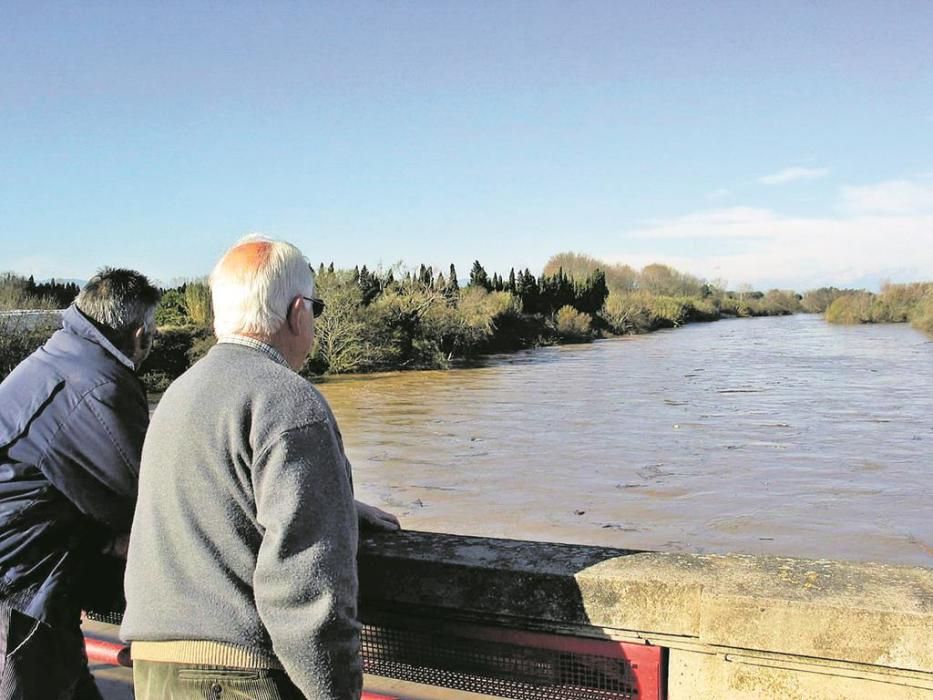 Dos homes observen el cabal del riu Ter a Torroella de Montgrí, després d'un fort temporal (2003).