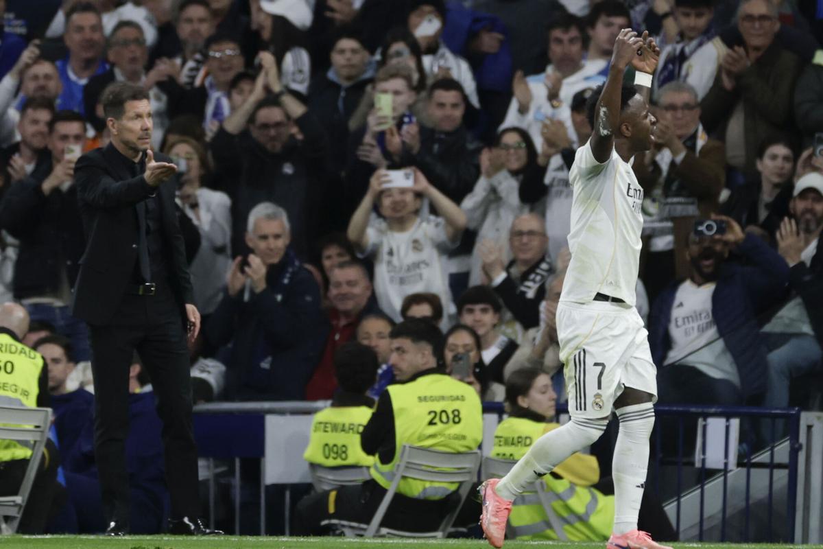 El delantero del Real Madrid Vinicius Junior (d) abandona el terreno de juega ante el técnico Diego Simeone, del Atlético, durante el partido de la jornada 29 de LaLiga que Real Madrid y Atlético de Madrid.