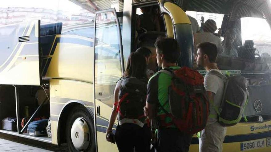 Un grupo de jóvenes toma un autobús de la empresa Vivas.