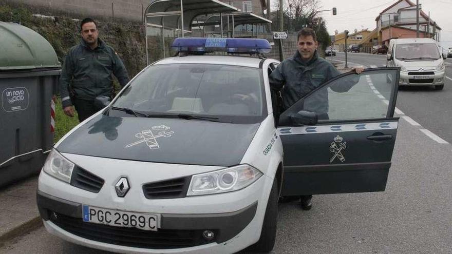 Marcos Campos y Javier Cancelas, ayer con el vehículo oficial en el cruce de A Guía, en Moaña. // S.Á.