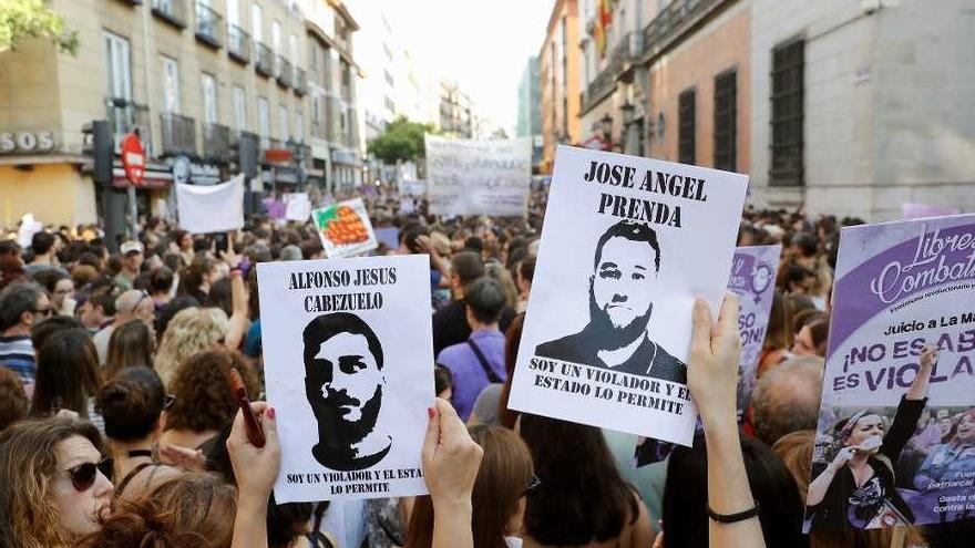 Varias mujeres portan carteles con la cara de los miembros de &#039;La Manada&#039; en una protesta.