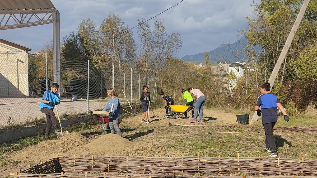 Alumnos y alumnas preparan la tierra que mezclarán con el compostaje.