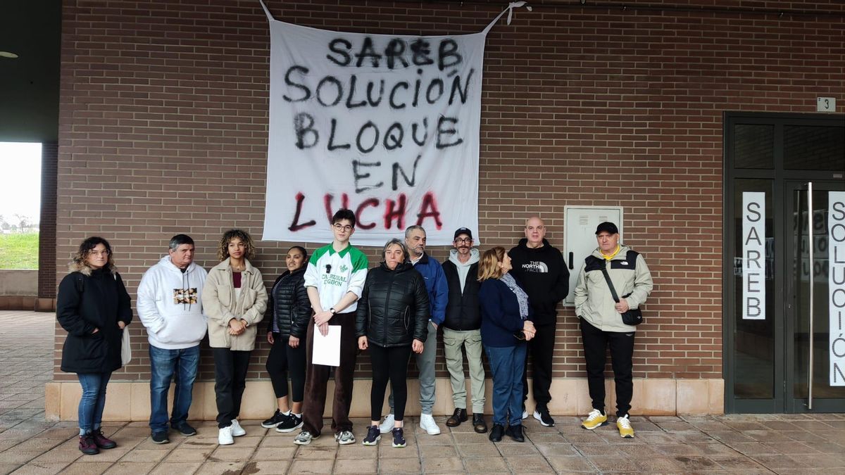 Vecinos de la calle Río Piloña, frente a una de las pancartas colocadas en su edificio.