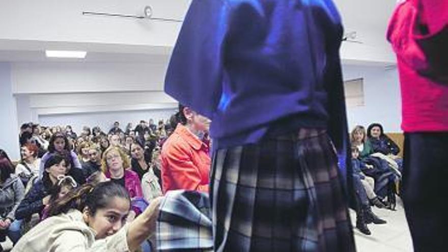 Una madre observa minuciosamente la falda del uniforme elegido.