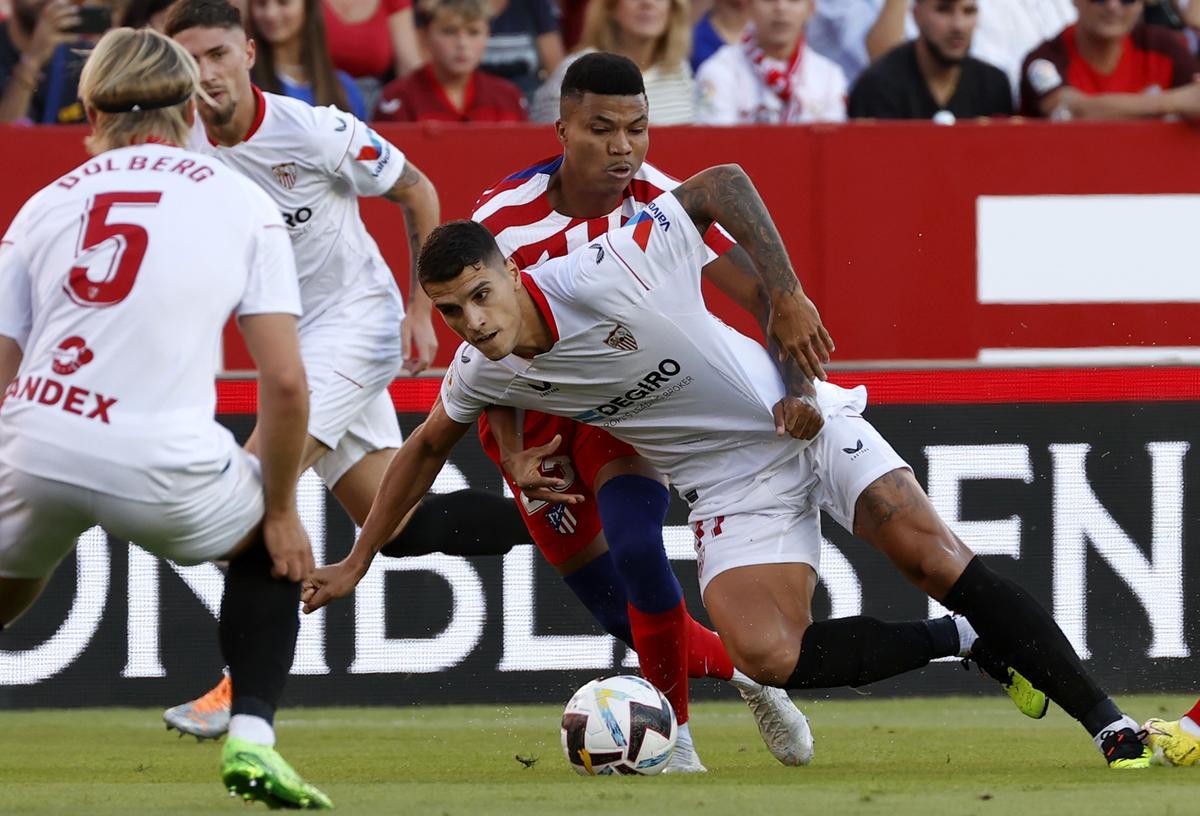 SEVILLA, 01/10/2022.- El centrocampista argentino del Sevilla FC Erik Lamela (delante) lucha con Reinildo Mandava, del Atlético de Madrid, durante el partido de la jornada 7 de LaLiga que se juega hoy sábado en el estadio Sánchez-Pizjuán, en Sevilla. EFE/Julio Muñoz