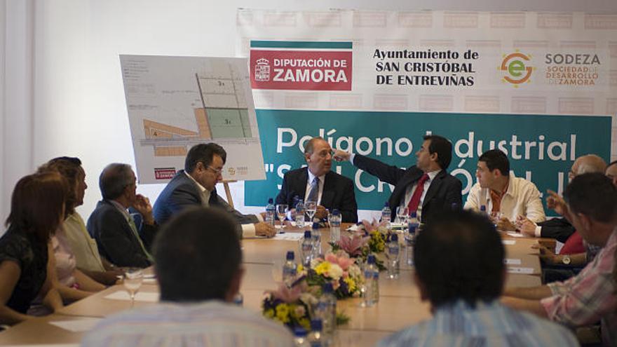 Martínez Maíllo señala el plano del futuro polígono industrial durante la reunión con empresarios de la zona