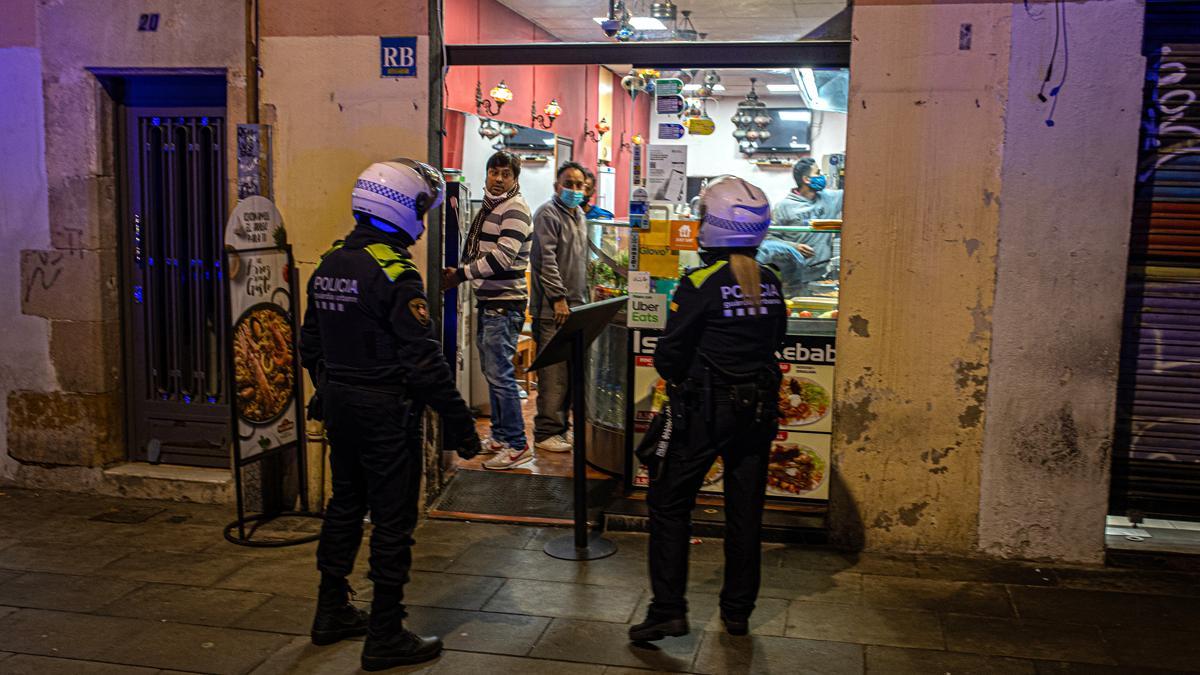 Agentes de Guardia Urbana controan el cierre de un negocio del Raval casa tras el toque de queda