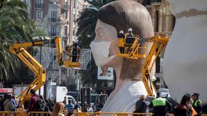 Las Fallas de Valencia, aplazadas por el coronavirus. En la imagen, la falla municipal ataviada con una mascarilla, tras la suspensión de la fiesta.