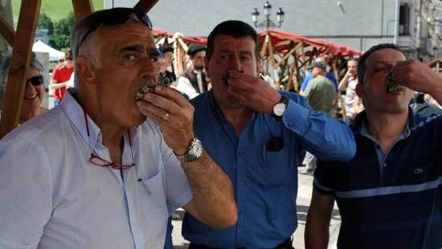 Jose Ángel Pérez, José Antonio Barrientos y Juan Expósito, edil de Castropol, comiendo ostras en el mercado.