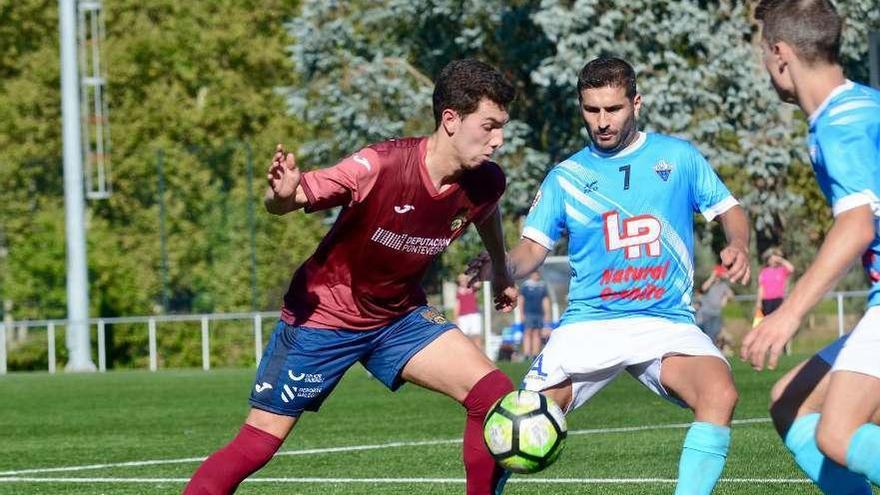 Un jugador del Pontevedra B intenta superar a dos defensas del Caselas. // Rafa Vázquez