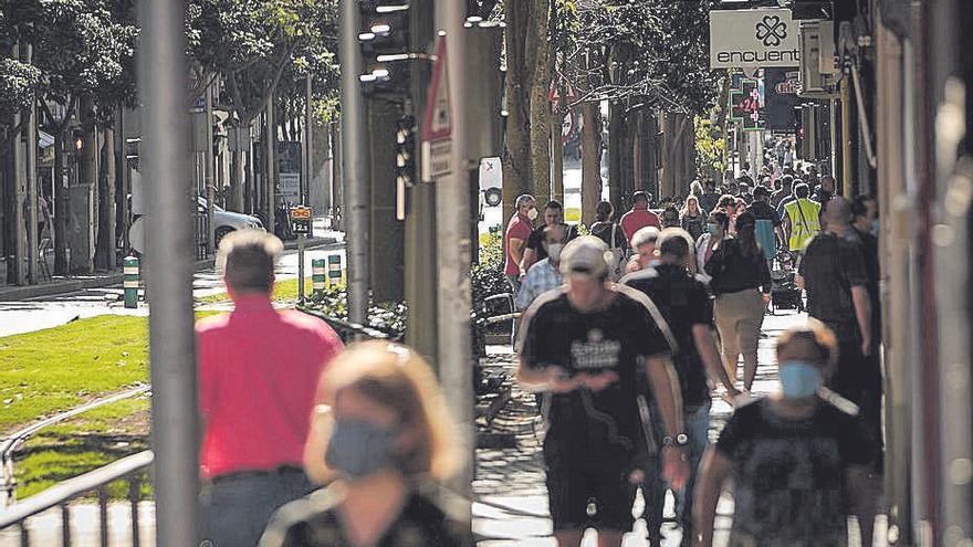 Un grupo numeroso de personas camina por Santa Cruz.