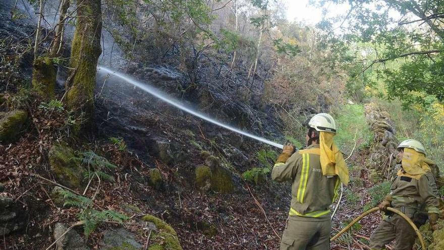 Dos brigadistas trabajan en la extinción del incendio de ayer. // Rafa Vázquez