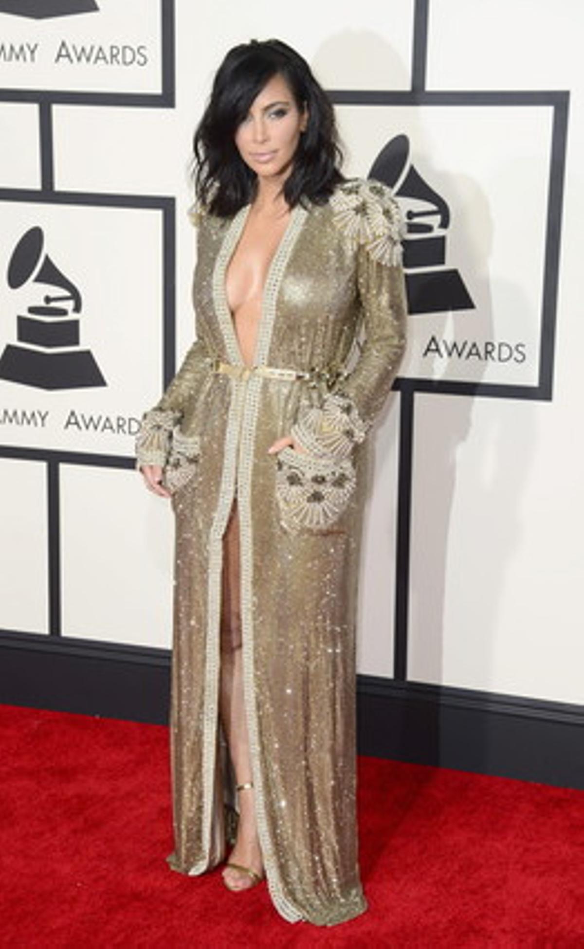 Kim Kardashian, luciendo escote y muslo, eligió un modelo dorado con casi total obertura frontal. Fiel a su estilo.