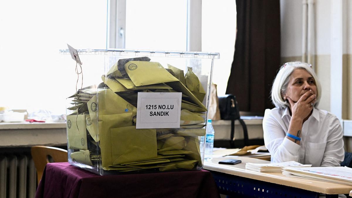 Una mujer junto a una caja con votos en un colegio electoral durante las elecciones presidenciales y parlamentarias, en Estambul, Turquía