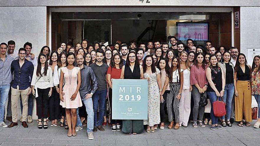 Foto de grupo de las autoridades con los nuevos residentes ante la fachada de la sede colegial.